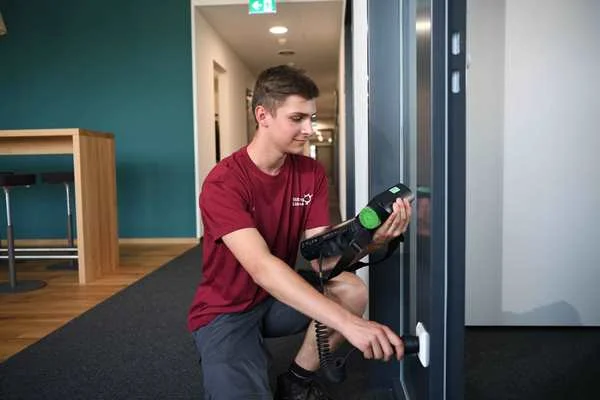 Das Bild zeigt einen jungen Mann der an einer Steckdose arbeitet