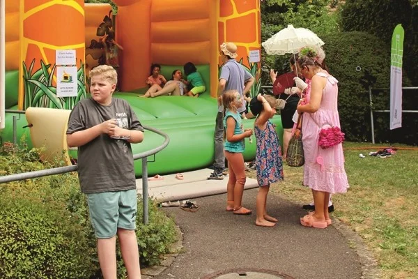 Das Bild zeigt eine Kinderhüpfburg und Kinder die in dieser spielen
