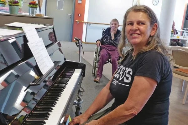 Das Bild zeigt eine frau die am Klavier sitzt