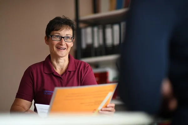 Das Bild zeigt eine Frau und eine weitere Person in einem Beratungsgespräch