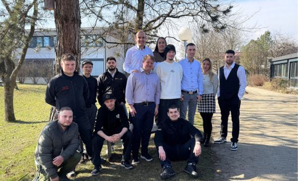 Eine Personengruppe lächelt in die Kamera