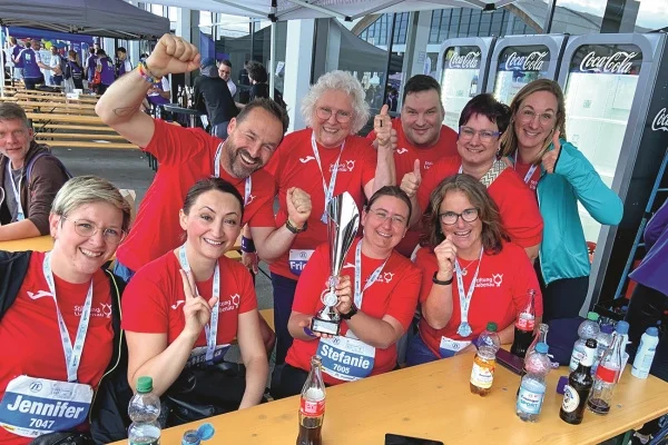 Mitarbeitende der Stiftung Liebenau beim Firmenlauf in Friedrichshafen. Das Bild zeigt eine Sportmannschaft mit Pokal