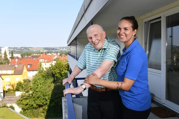 Das Bild zeigt einen Mann und eine Frau auf einem Balkon