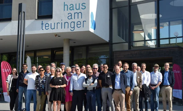 internationale gäste der stiftung liebenau besuchen bei einem fachaustausch einrichtungen in oberteuringen. das bild zeigt eine gruppe von menschen vor dem haus zum teuringer.