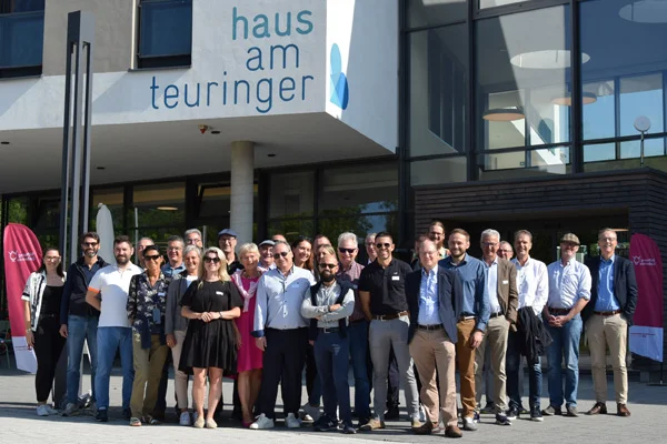 internationale gäste der stiftung liebenau besuchen bei einem fachaustausch einrichtungen in oberteuringen. das bild zeigt eine gruppe von menschen vor dem haus zum teuringer.
