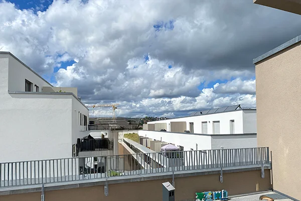 Das Bild zeigt den Blick von einer Terrasse auf eine Hausanlage