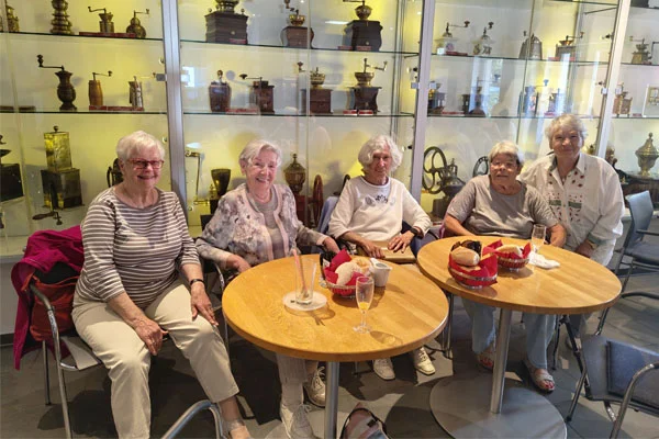 Kaffeemühlenmuseum Besucher und Besucherinnen sitzen im Kaffeemühlenmuseum