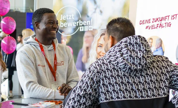 Zwei Männer unterhalten sich an einem Stehtisch auf einer Messe
