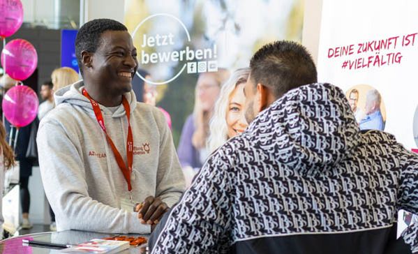 Zwei Männer unterhalten sich an einem Stehtisch auf einer Messe