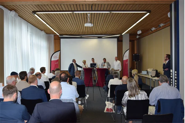 Fachaustausch mit internationalen Expertinnen und Experten. das bild zeigt expertinnen und experten bei einem internationalen fachaustausch der stiftung liebenau in einem vortragsraum.