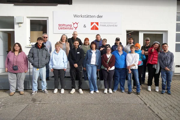 Die Gruppe Eine Gruppenfoto mit vielen Personen vor der Werkstatt.