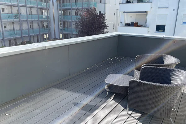 Das Foto zeigt die Terrasse mit einem Tisch und zwei Stühlen.