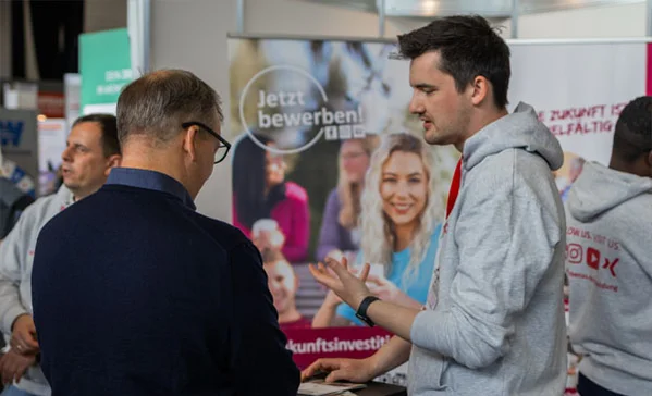 Zwei Männer unterhalten sich an einem Messestand
