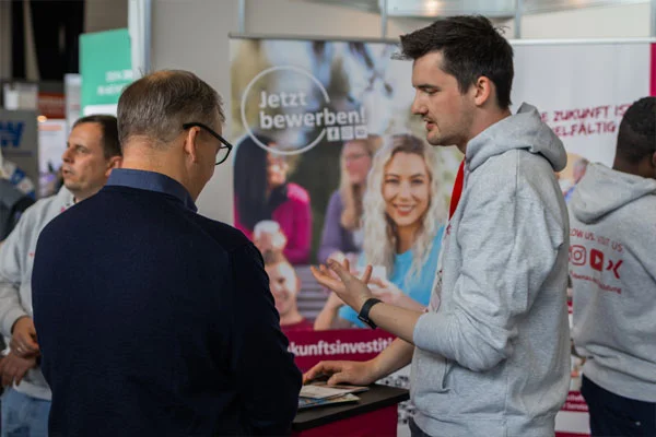 Zwei Männer unterhalten sich an einem Messestand