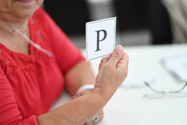 Soziales gestalten Das Foto zeigt eine Person mit einem Zettel mit dem Buchstaben P.