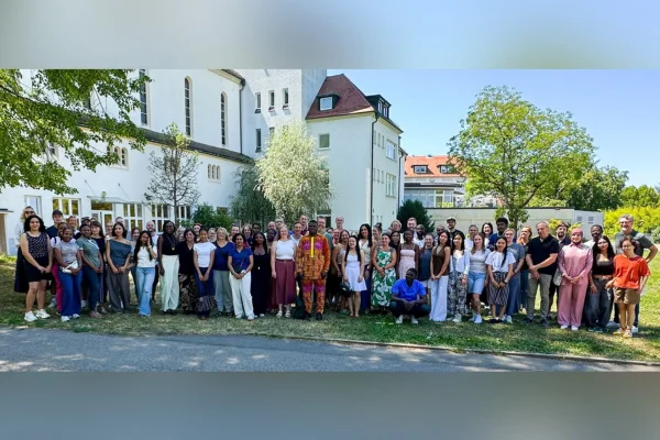 Viele junge Menschen stehen zusammen und schauen in die Kamera.