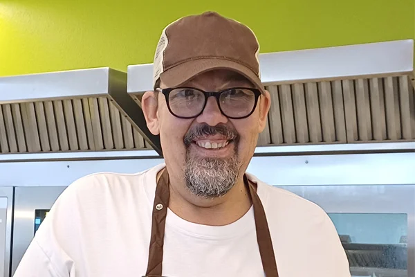 Ein Portraitfoto eines Manns, der in die Kamera lächelt.