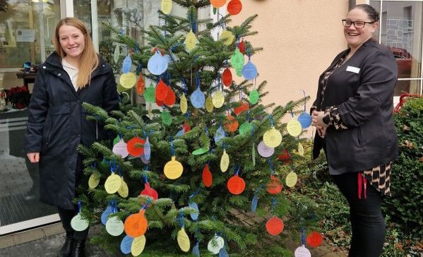 Das Bild zeigt Myriam Haag vom Sozialdienst und Einrichtungsleiterin Natalie Hoss vor dem Wunschbaum