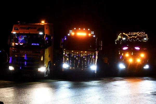 Nikolausfahrt Drei LKWs mit bunten Lichterketten