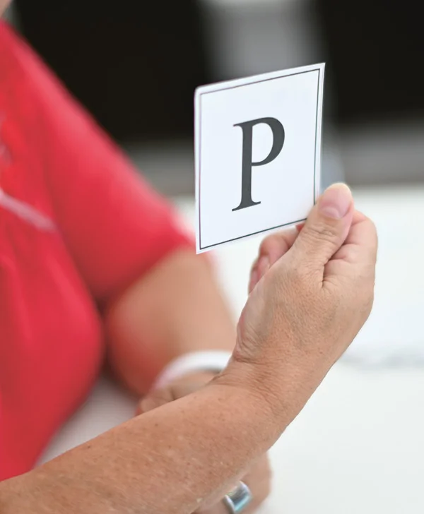Das Foto zeigt eine Hand mit einem Zettel mit dem Buchstaben P.