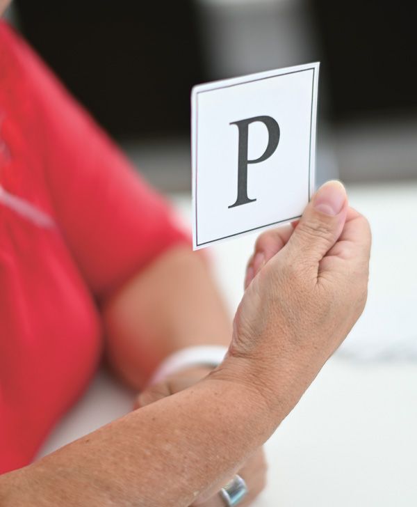 Das Foto zeigt eine Hand mit einem Zettel mit dem Buchstaben P.