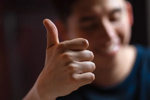 Das Bild zeigt einen Mann der den Daumen hoch in die Kamera zeigt.