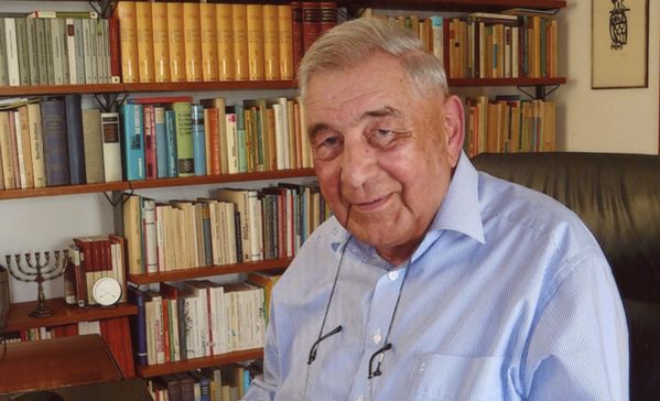 das bild zeigt monsignore norbert huber vor einem bücherregal