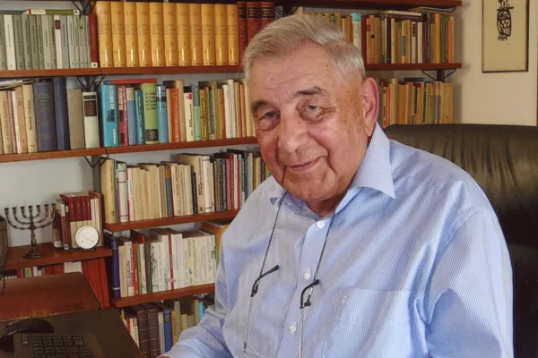 das bild zeigt monsignore norbert huber vor einem bücherregal