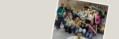 Ein Gruppenbild mit den beteiligten Personen vom Tag der Kinderhospizarbeit. Die Personen halten grüne Bänder hoch.