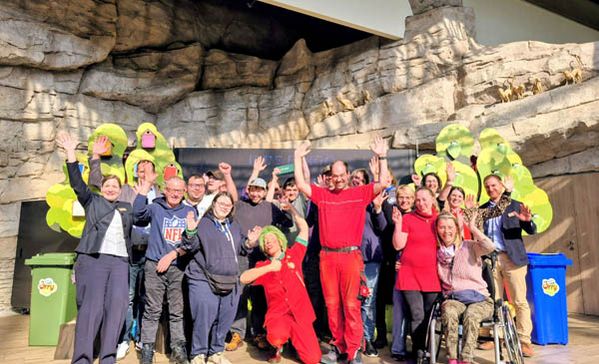 Viele Personen bei einem Gruppenbild strecken die Hände in die Luft.