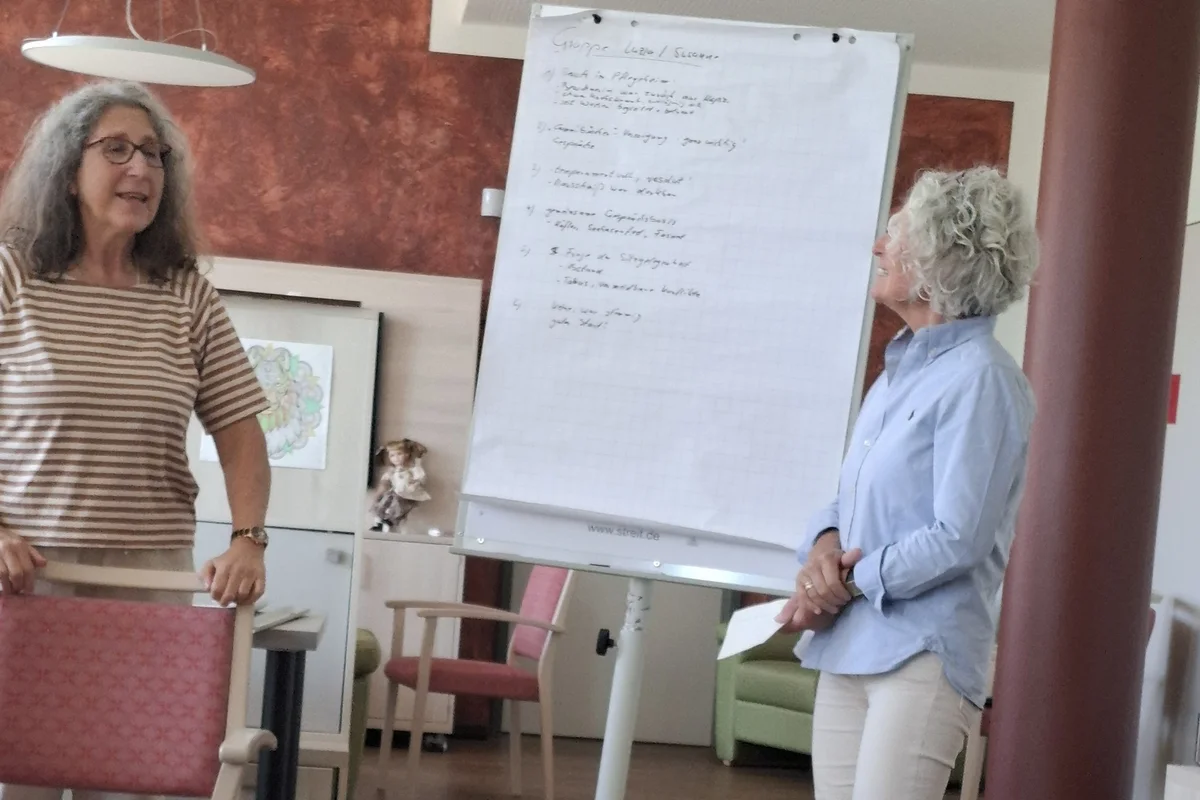 Zwei Frauen stehen vor einem Flipchart und halten einen Vortrag.