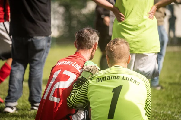 das bild zeigt zwei fußballer von hinten, der eine legt die hand auf der schulter des anderen ab.