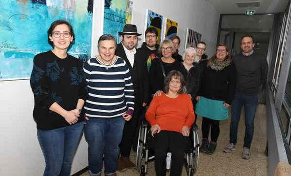 Das Bild zeigt Projektbeteiligte der Ausstellung vor den Gemälden