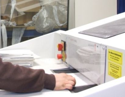 Das Bild zeigt die Vernichtung von Akten an einem Schredder