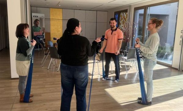 Vier Personen trainieren mit Bändern.