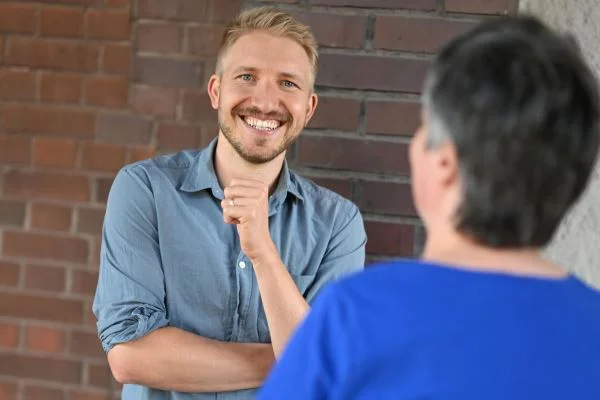 Auf dem Bild sieht man einen Mann der in die Kamera lacht