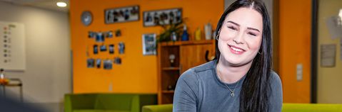 Das Bild zeigt eine junge Frau in einem Wohnbereich