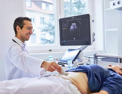 Das Bild zeigt einen Arzt am Sonografiegerät