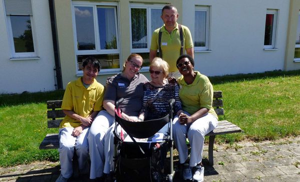 Das Foto zeigt einige Mitarbeiterinnen und Mitarbeiter und eine Bewohnerin.