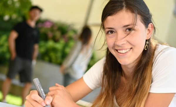 Das Bild zeigt eine Studentin vor der Akademie Schloss Liebenau