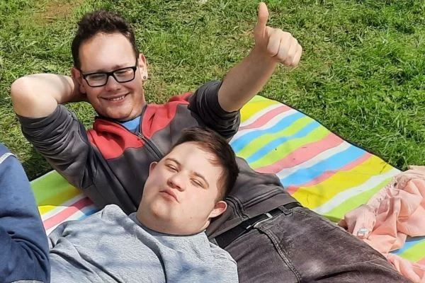 Das Bild zeigt einen jungen Mann mit einem Kind
