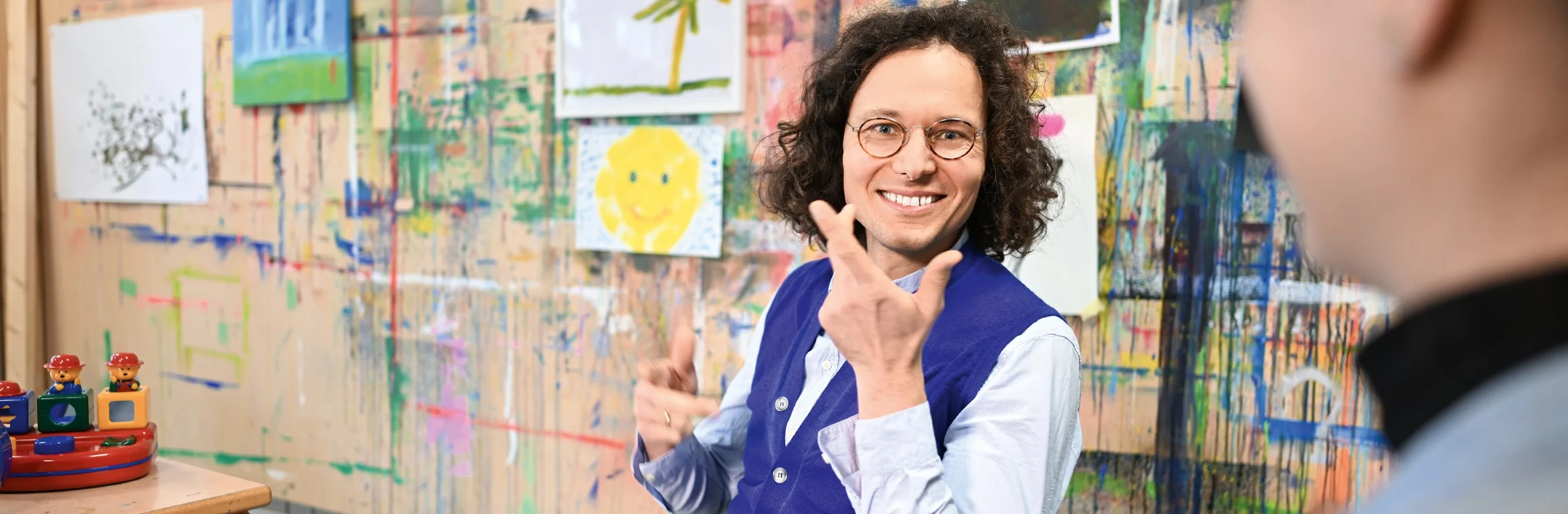 Das Bild zeigt einen jungen Mann im Gespräch der lächelt