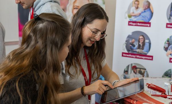 Zwei Frauen unterhalten sich an einem Messestand