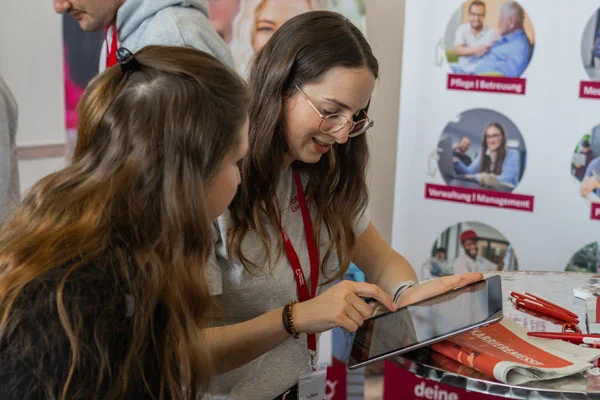 Zwei Frauen unterhalten sich an einem Messestand
