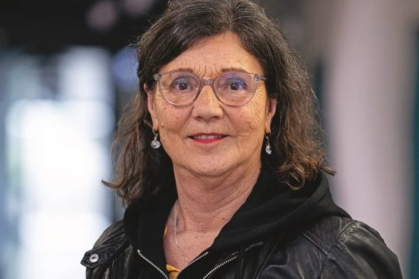 Das Bild zeigt eine frau in einem schwarzen Oberteil die in die Kamera lächelt