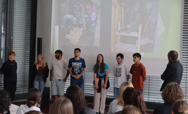 Mehrere Schüler stehen auf einer Bühne und präsentieren ihr Projekt.