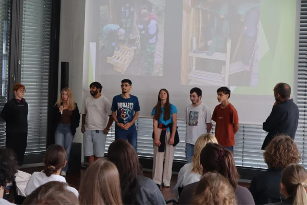 Mehrere Schüler stehen auf einer Bühne und präsentieren ihr Projekt.