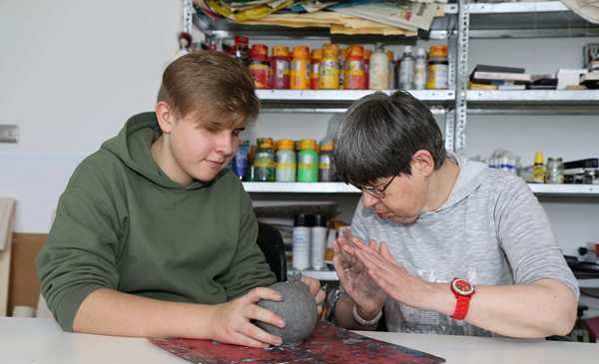 Das Bild zeigt Tim mit einer Künstlerin in der Kreativerwerkstatt Rosenharz
