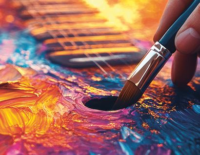 Eine Hand mit Pinsel und vielen Farben.