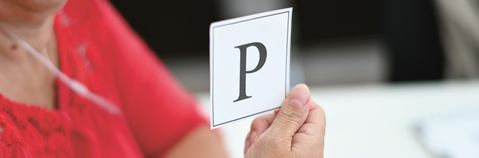 Das Foto zeigt eine Hand mit einem Zettel mit dem Buchstaben P.